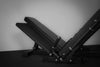 Black cushioned weight bench with on a gray background