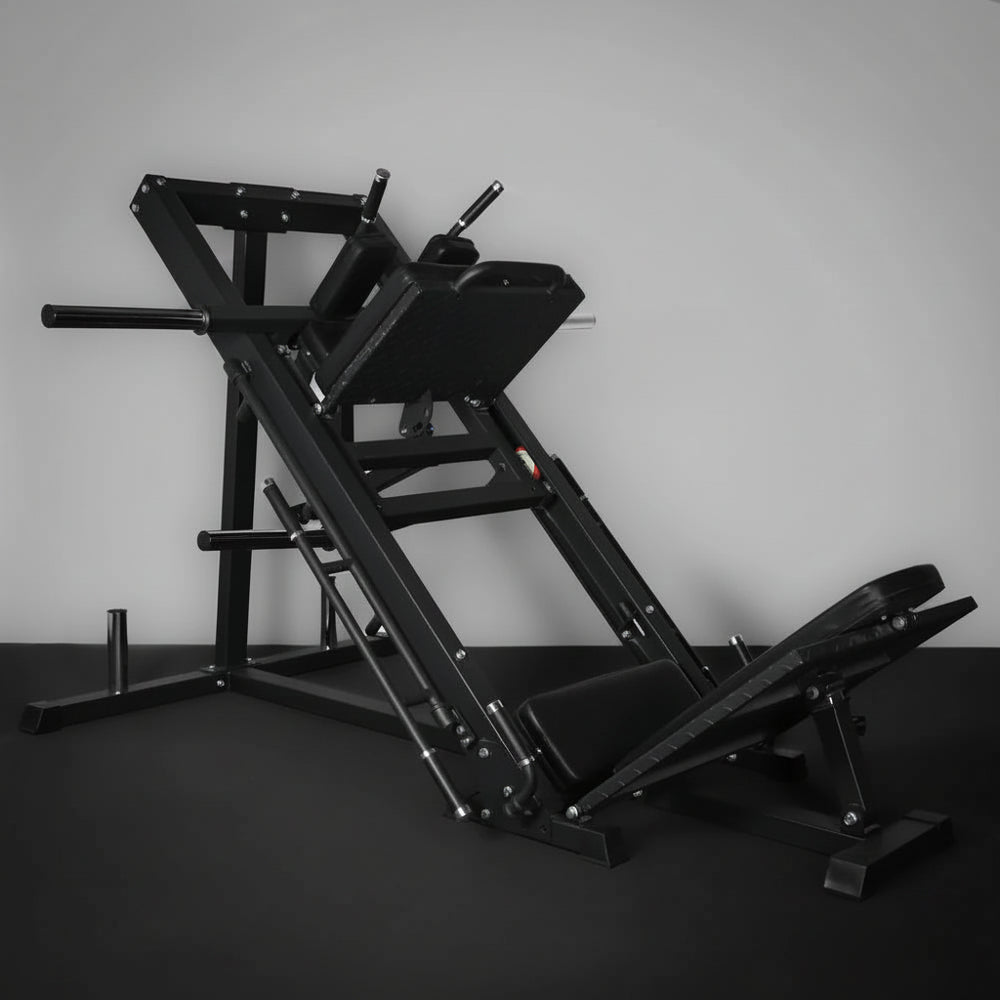 Black leg press machine against a gray wall