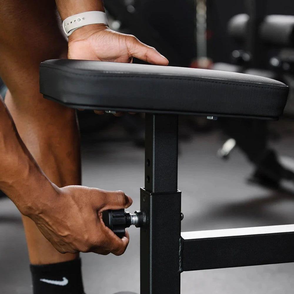 Person adjusting a seat in a gym setting