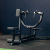 Black weight machine against a dark blue wall