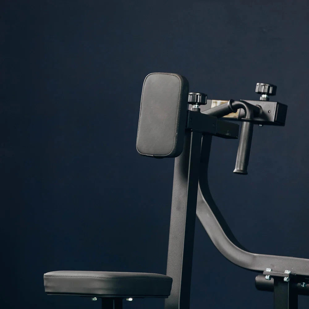 Gym row machine with arm support against a dark blue background