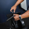 Person using a rowing machine with a focus on hands and equipment.