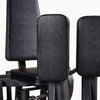 Close-up of black leather cushioned pads on a gym machine with a white background