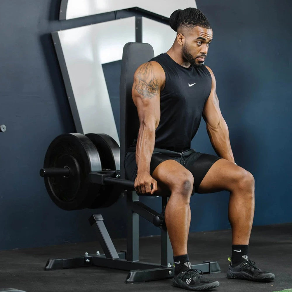 Man in black athletic wear sitting on a dip machine in a gym