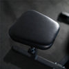 Black leather seat cover on a gym machine with a dark background