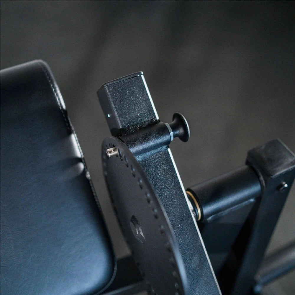 Close-up of a black leather cushion and adjustment dial on a dark background