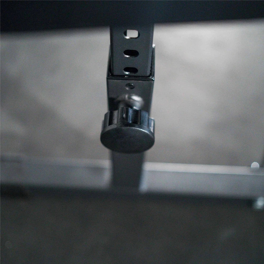 Close-up of pin adjustment on a preacher curl gym machine on a metallic surface