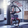 Man exercising on a gym machine with motivational wall text in the background