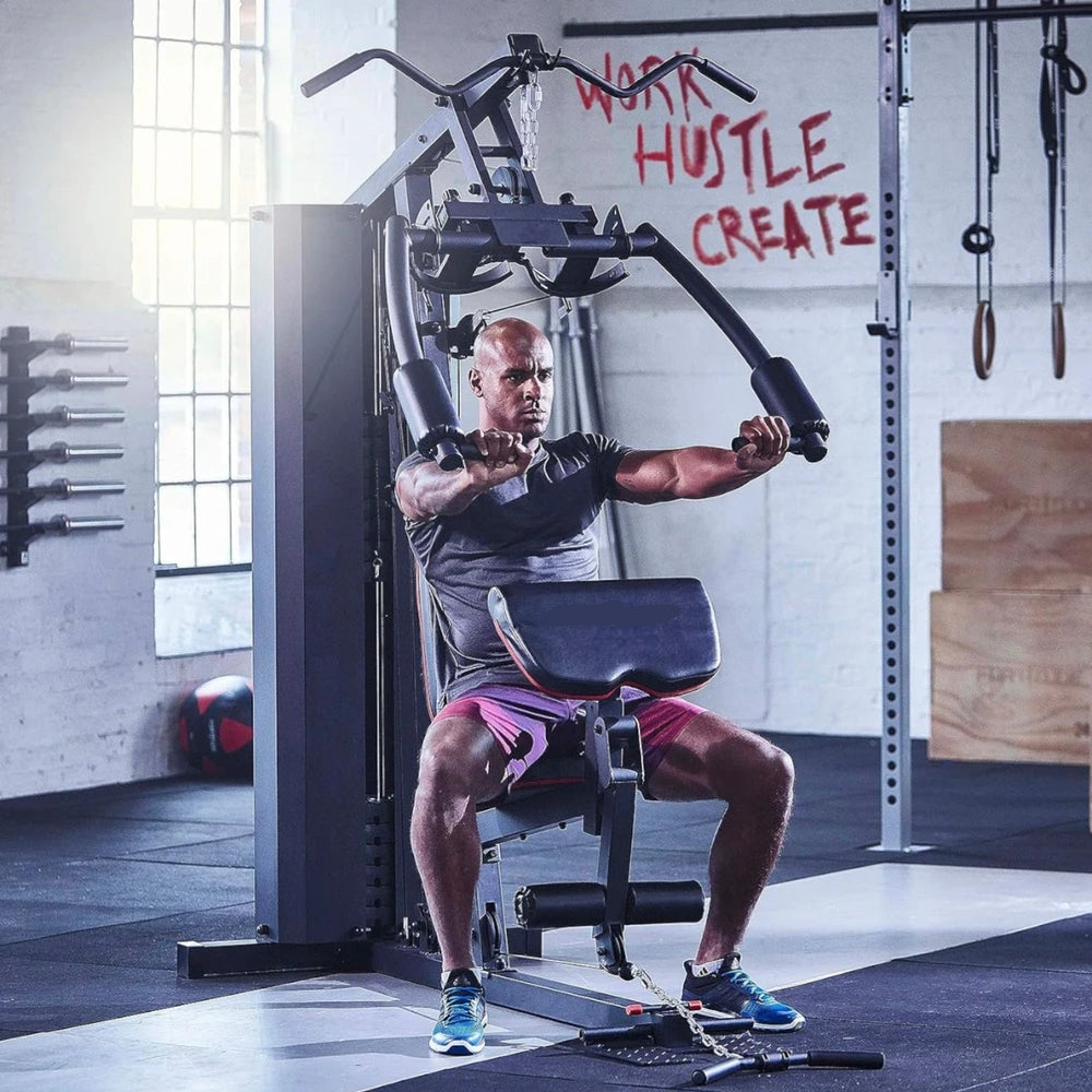Man exercising on a gym machine with motivational wall text in the background
