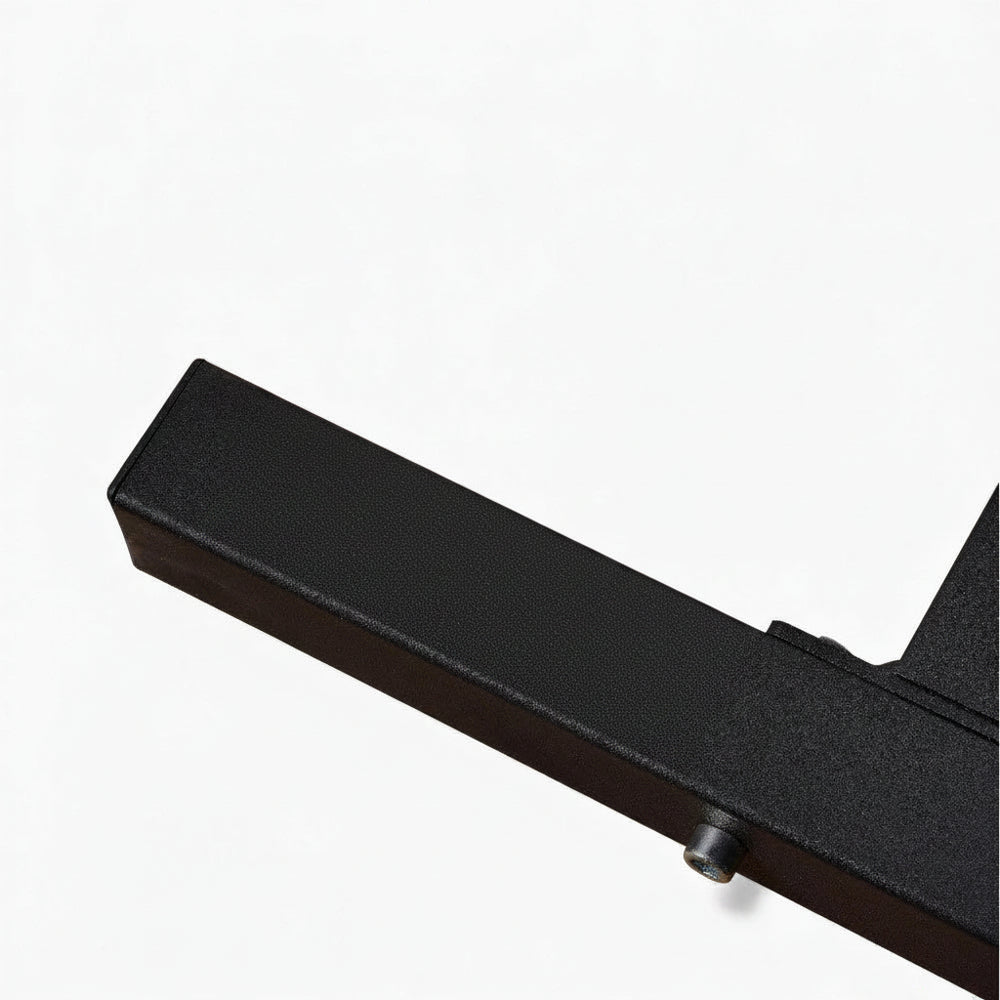 Close up of a sturdy black steel metal leg of a leg extension curl machine on a white background