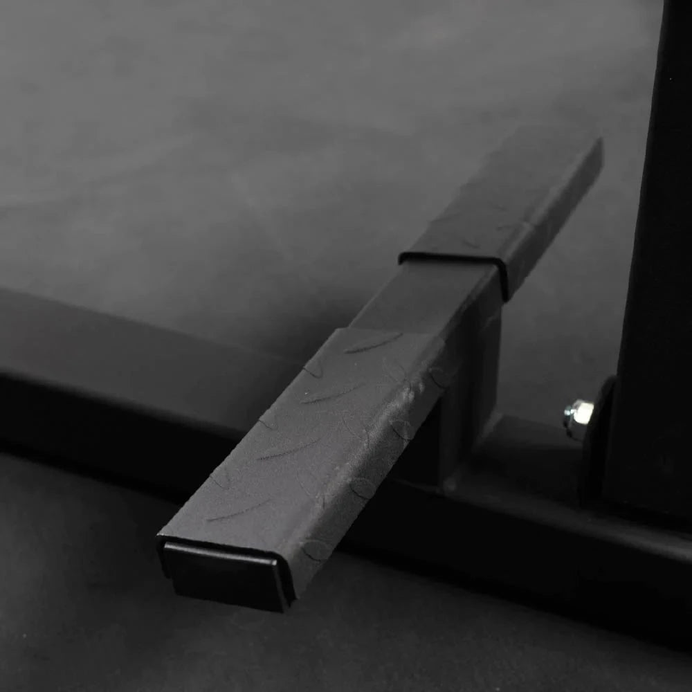 Close-up of a black metal foot rest on a textured surface