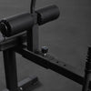 Foam roller pads on a leg curl machine against a dark background