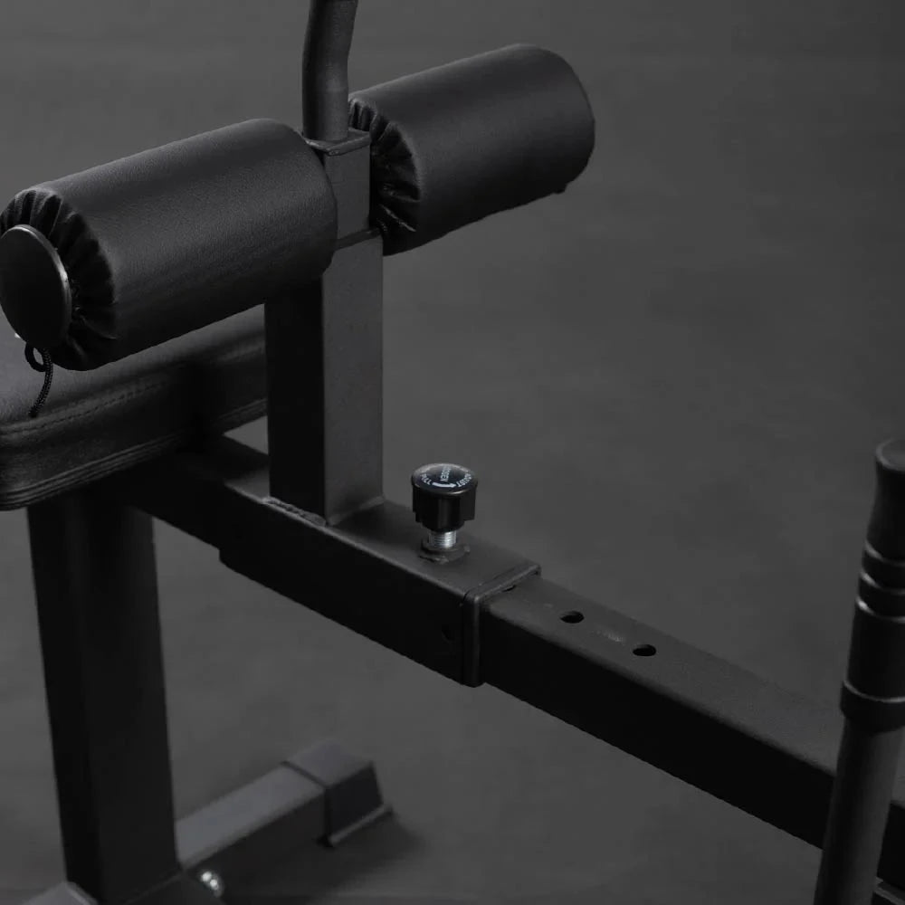 Foam roller pads on a leg curl machine against a dark background