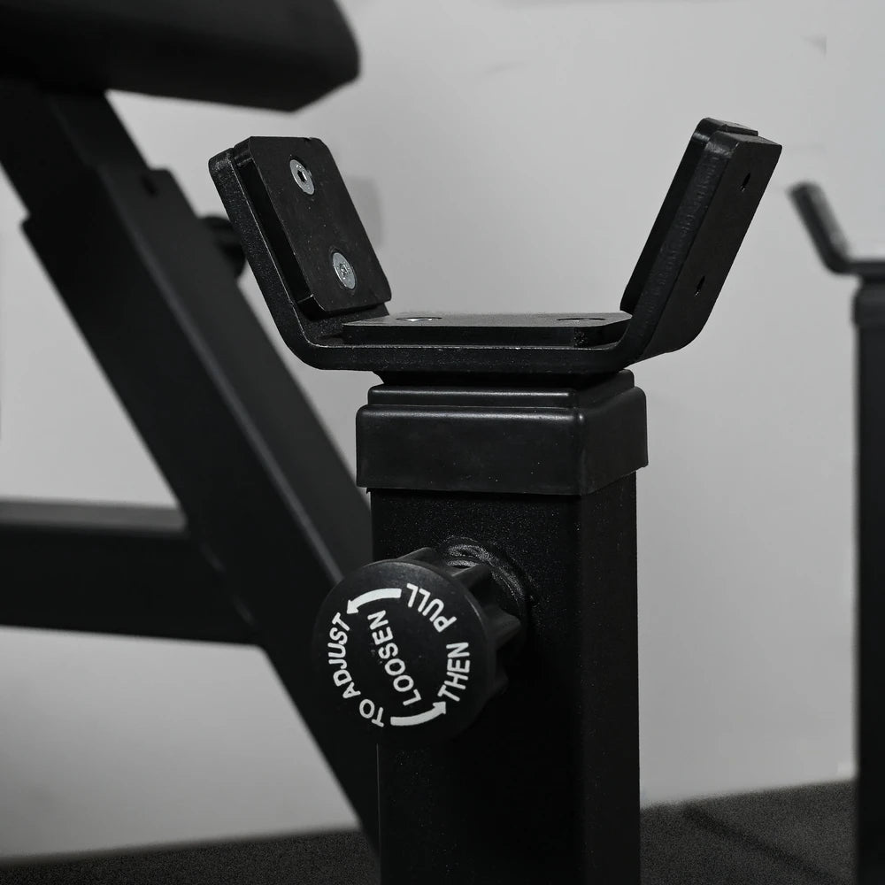 Close-up of a black exercise machine with a focus on the seat post and control knob.
