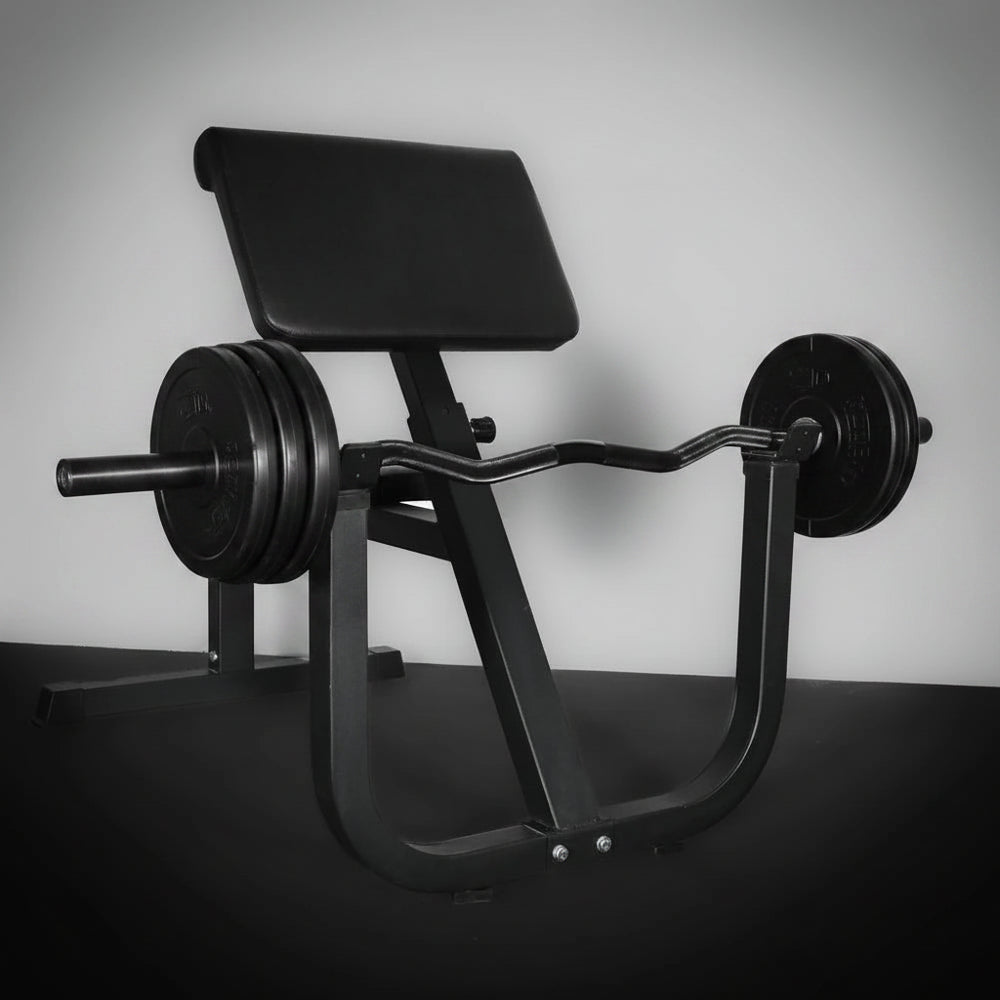 Black weight bench with weights on a dark floor against a light wall