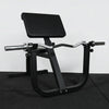 Black gym machine on a dark floor with a white wall background