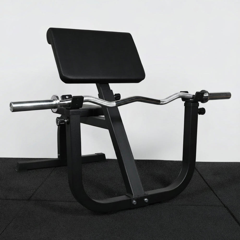 Black gym machine on a dark floor with a white wall background
