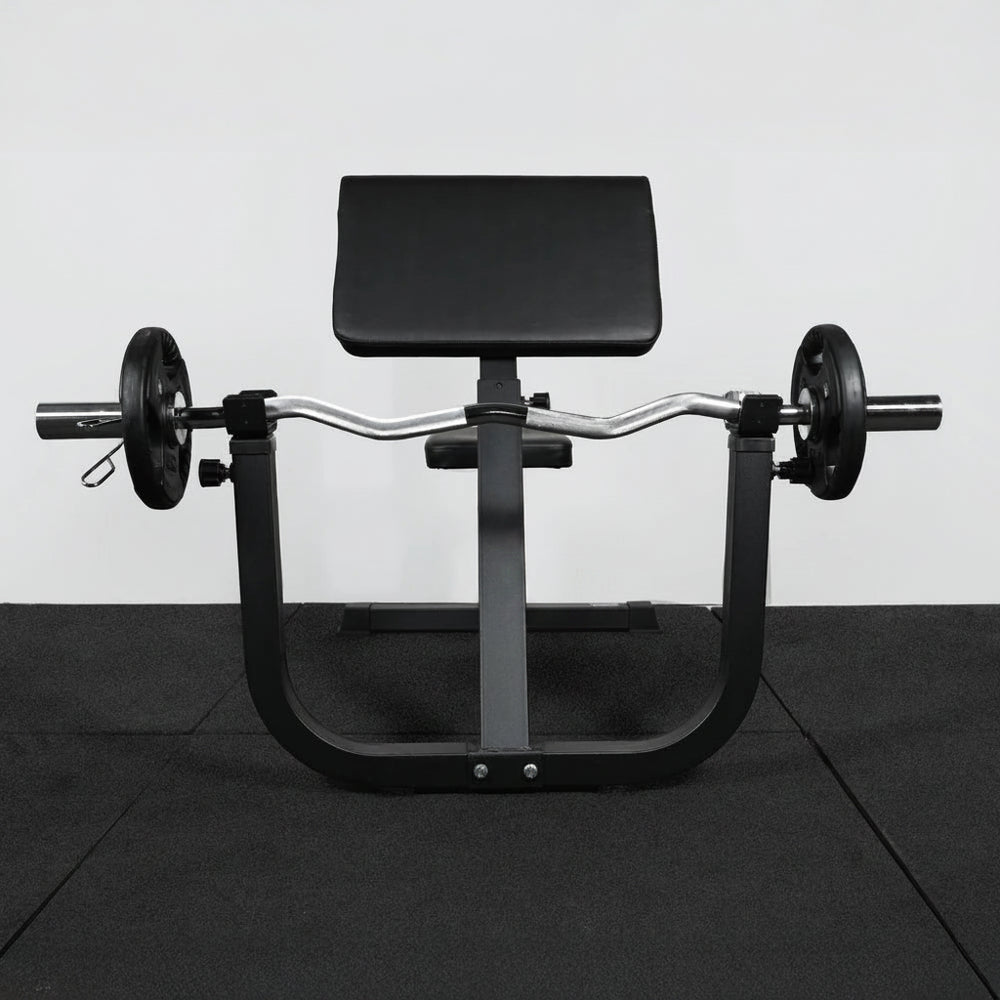 Front view of black steel frame preacher curl bench on black tiled floor and white walls