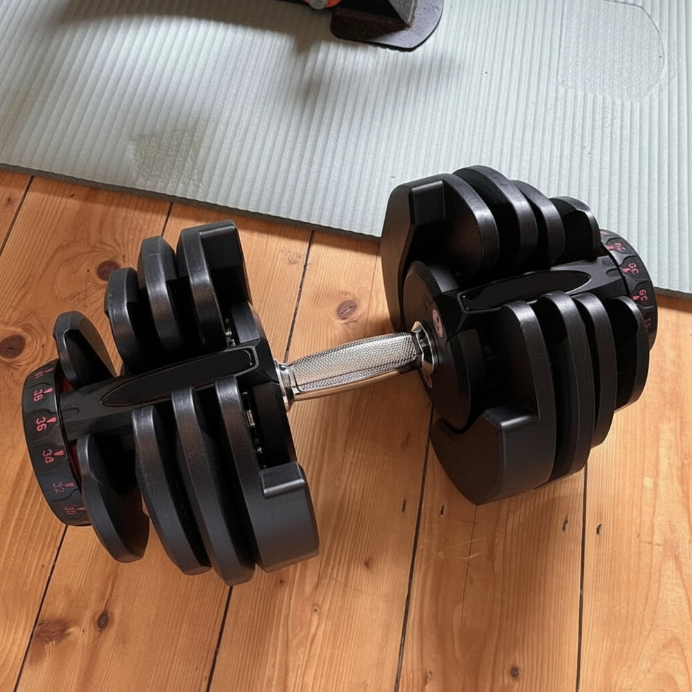 Black dumbbell with adjustable weight options on wooden floor
