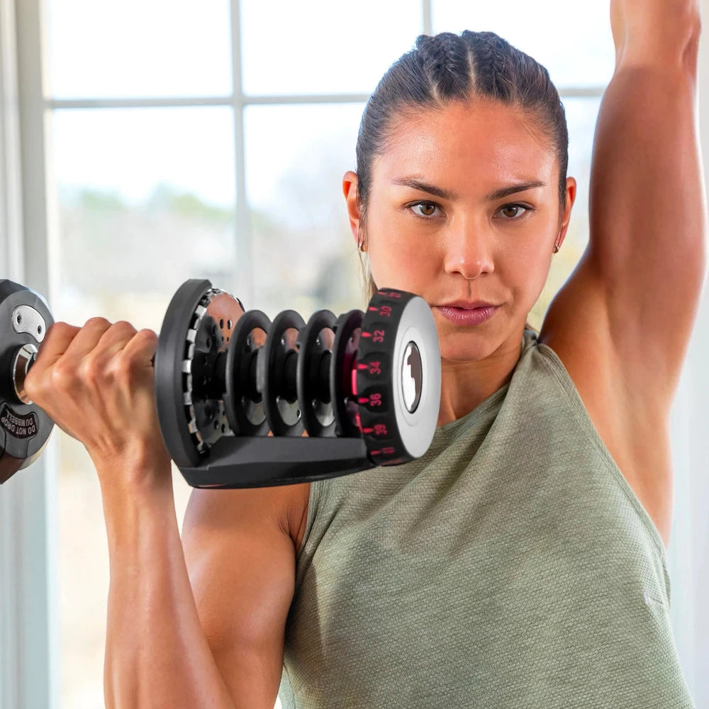 Woman lifting a dumbbell with a window in the background