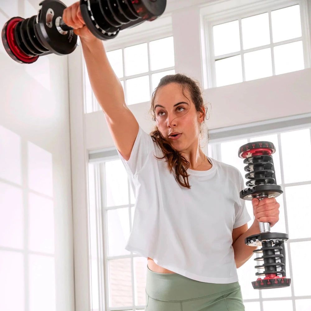 Woman holding dumbbells in a home enviroment