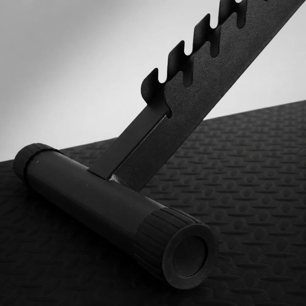 Close up of adjustable gym bench detail on a textured black floor