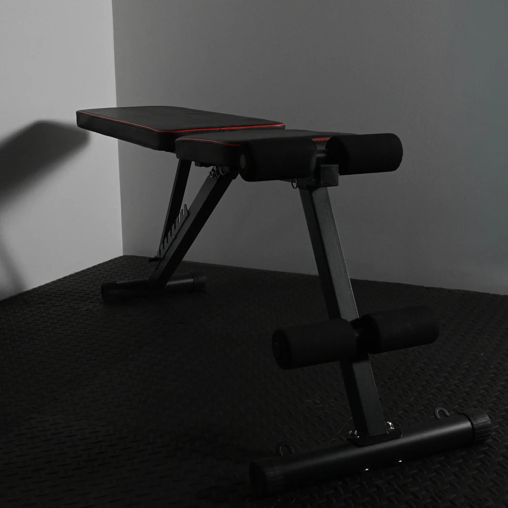 Gym bench in flat position on black textured floor and grey walls