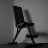Gym bench with red piping on a black floor and grey background