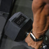 Close up of arm holding a 25kg dumbbell in gym setting