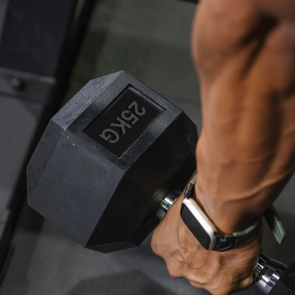 Close up of arm holding a 25kg dumbbell in gym setting