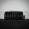 Full weight plate rack on black floor and grey wall