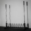 Gym plate and barbell storage rack on black floor