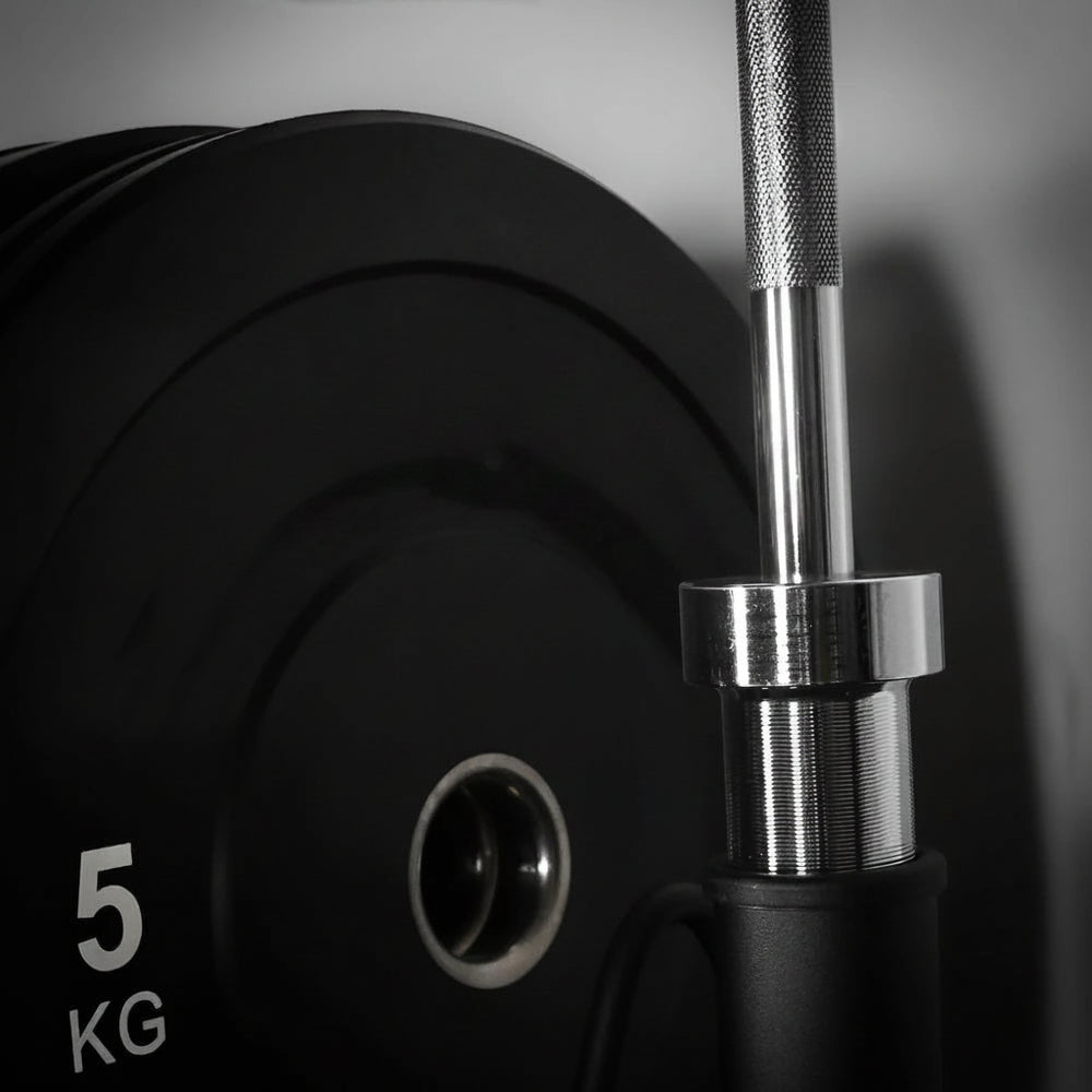 Close up of 5kg gym weight plate and barbell