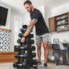 Man organizing a dumbbell set in a home setting