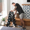 Man organizing a stack of dumbbells in a home setting.