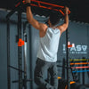 Person performing pull-ups on a pull-up bar in a gym setting.