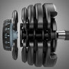 Close up of different weight plates for adjustable dumbbell on grey background