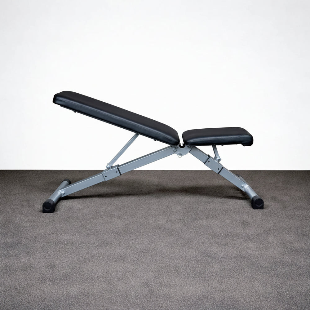 Black adjustable weight bench on a gray floor with a white wall background