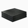 Stack of black rubber floor tiles for commercial gym use on a white background