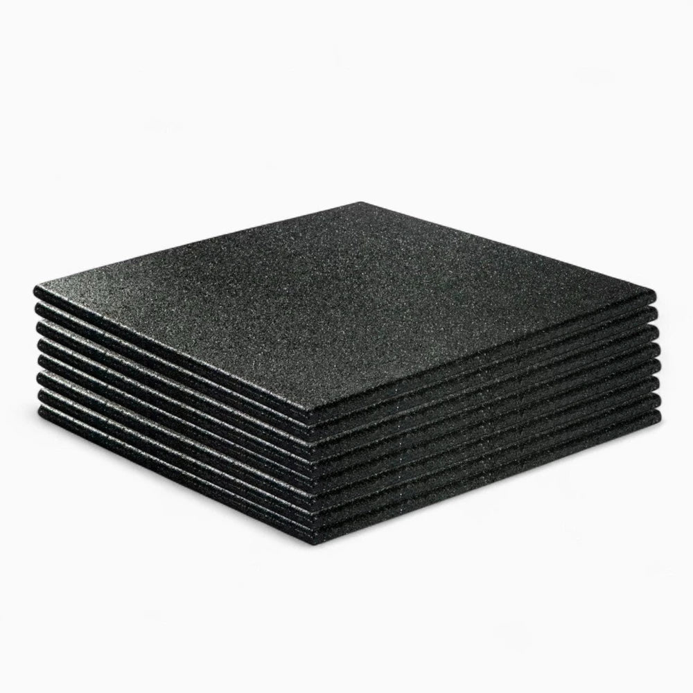 Stack of black rubber floor tiles for commercial gym use on a white background