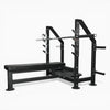 Sideways view of gym bench with barbell on rack above on a white background