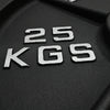 Close up of silver 25kgs embossed onto a black weight plate