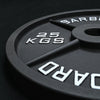 Close up of a 25kg black weight plate on a black background
