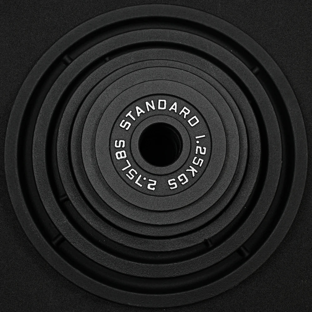 Set of different sized black weight plates on a black background