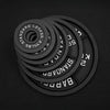 Set of black cast iron weight plates on a black background