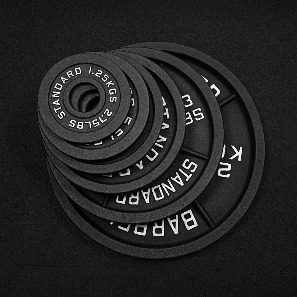 Set of black cast iron weight plates on a black background