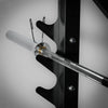 Metal barbell attached to a black rack on a gray background