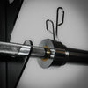 Close-up of a barbell with weight plates on a neutral background