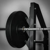 Close-up of a barbell with weight plates on a gray background