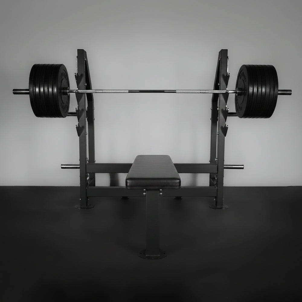 Barbell with weights on a weight rack against a plain wall.